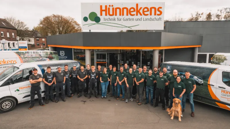 Das Team von Hünnekens mit Servicefahrzeugen vor dem Firmengebäude in Straelen