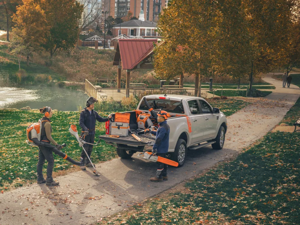 Profis bei der Laubbeseitigung mit Blasgeräten und Transporter