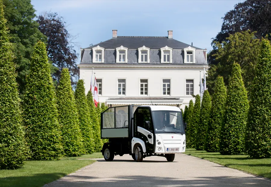 Addax Elektrofahrzeug steht in einem Park vor einen großen weißen Haus.